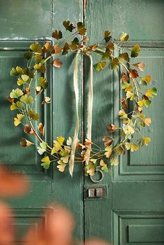 a green door with a wreath hanging on it