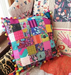 a colorful patchwork pillow sitting on top of a chair