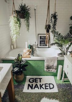 a bathroom with green tile and potted plants