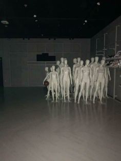 a group of white mannequins standing in a room