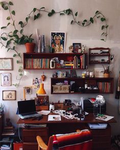 a home office with bookshelves and plants on the wall