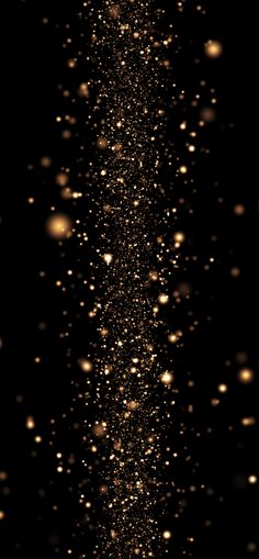 gold glitter on black background with space for text