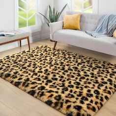 a living room area with a couch, chair and leopard print rug on the floor