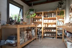 a room filled with lots of pots and containers on shelves next to windows in front of a window