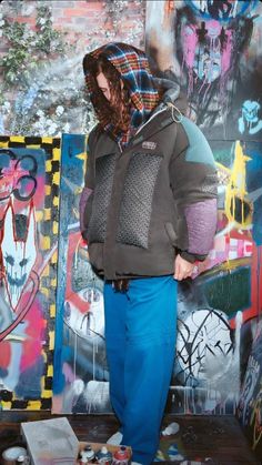 a man standing in front of graffiti covered walls