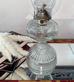 a glass table with a lamp on top of it next to a rug and other items