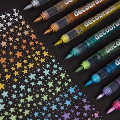 several crayons are lined up next to each other on a black background with stars