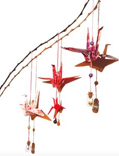 three origami birds are hanging from a string with beads and bottles attached to them