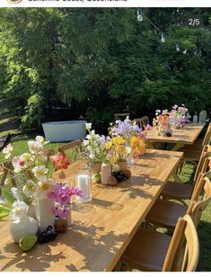 a long wooden table with vases and flowers on it in the middle of a grassy area