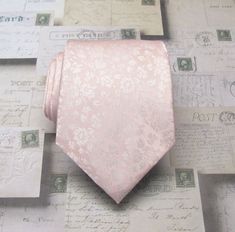 a pink neck tie sitting on top of some old paper with writing all over it