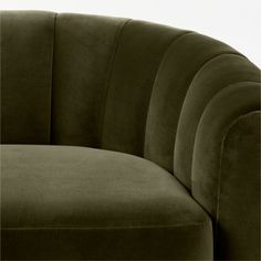 an olive green velvet sofa with rounded arms