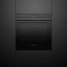 an oven built into the side of a black wall in a room with dark walls