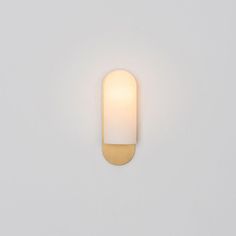 a white wall light with a round glass shade