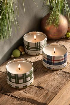 three candles sitting on top of a wooden table