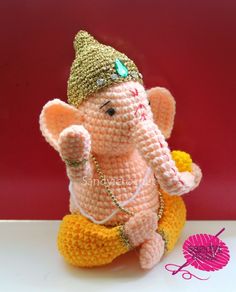 a small crocheted elephant sitting on top of a table