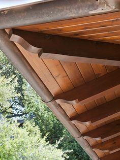 the roof of a wooden building with trees in the background