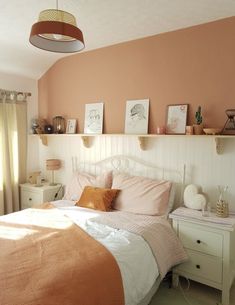 a bed room with a neatly made bed and some pictures on the wall above it