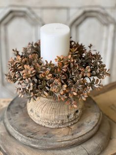 a white candle sitting on top of a wooden table