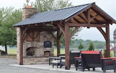 an outdoor fireplace with chairs around it