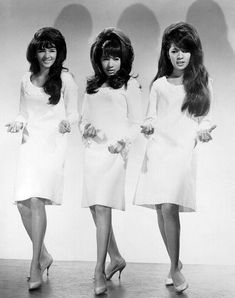 three women in white dresses standing next to each other