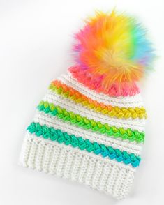 a multicolored knitted hat with a pom - pom on top