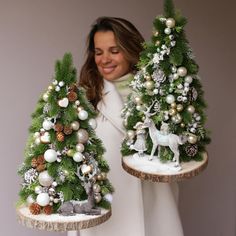 a woman holding two trays with christmas trees on them