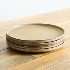 a stack of three plates sitting on top of a wooden table next to each other