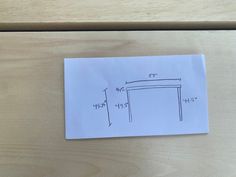 a piece of paper that is on top of a wooden table with measurements for the legs