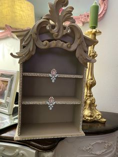 an ornate wooden shelf with jewelry on it