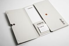 an opened white book with business cards in it