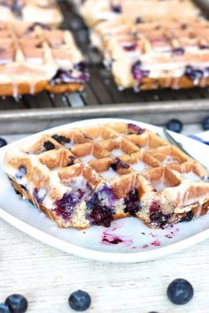 blueberry waffles are sitting on a white plate next to a cooling rack