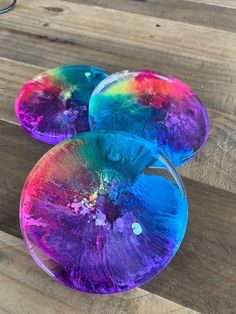 three colorful plates sitting on top of a wooden table