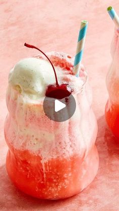 two frozen drinks with strawberries and ice cream in them on a pink tablecloth