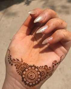 a woman's hand with a henna tattoo on it