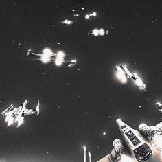 several fighter jets flying through the air with lights on in front of them and stars above