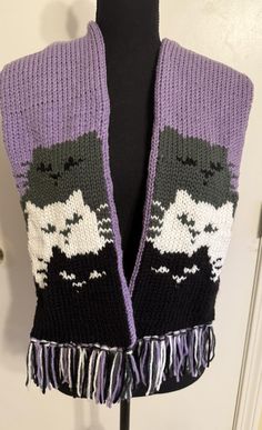 a purple and black knitted scarf on a mannequin