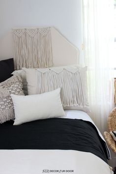 a white bed with black and white pillows