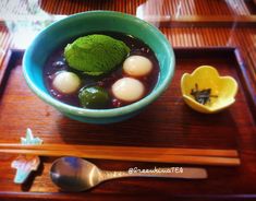 a bowl of soup with broccoli, eggs and other vegetables on a wooden tray