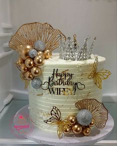 a birthday cake decorated with gold and silver decorations