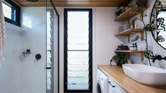 a washer and dryer in a bathroom with wood flooring on the walls