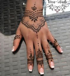 a woman's hand with henna tattoos on it