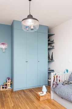 a baby's room with blue walls and wooden floors