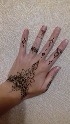 a woman's hand with henna tattoos on it