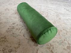 a green pillow is laying on the floor