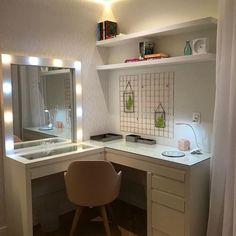 a desk with a mirror, sink and chair in front of the counter top is lit up by lights