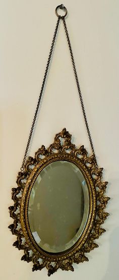 a mirror hanging on the wall with chains