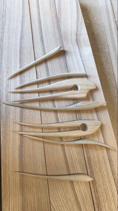 several wooden spoons are lined up on a table with wood strips in the middle