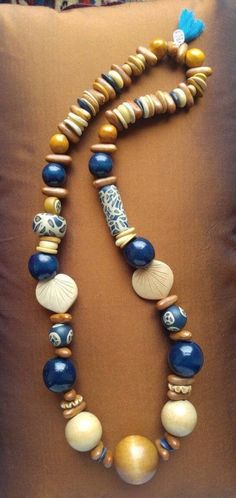 Handmade beaded necklace in earth tones of tan and ivory with navy accents.  Strung with vintage round and carved wooden and bone beads, handmade clay beads and seeds.  At 14 inches this necklace will easily slip over your head and make a stunning fashion statement.  A one-of-a-kind accessory.  As with all my necklaces, this is finished with a tassel and a charm reminding you this is made with love.  Enjoy! Luxury Wooden Beads Necklace As Gift, Wooden Beads Jewelry, Clay Beaded Necklace, Wooden Bead Jewelry, Clay Bead Necklace, Queens Jewels, Navy Accents, Stunning Fashion, Handmade Beaded Necklace