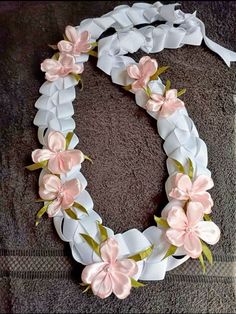 a white and pink wreath with flowers on the front is laying on top of a towel