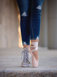 a woman in ripped jeans and pink ballet shoes